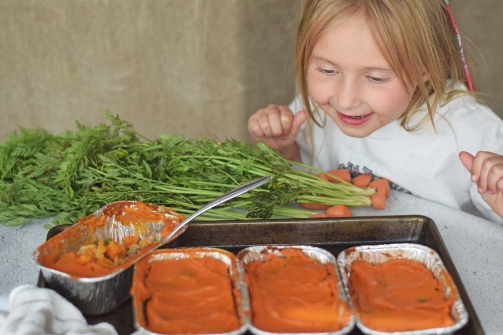 young girl looking excitedly at 3 gouda turkey pies in front of her